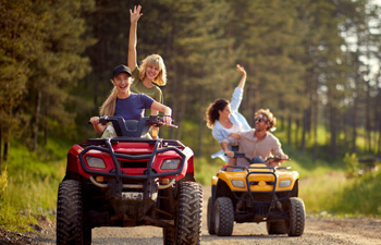 young adults riding quads on trail