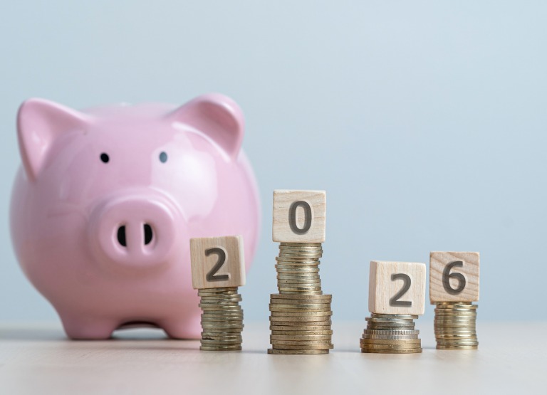 piggy bank with stacks of change with 2026 blocks on top