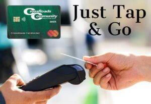 close up of person's hand using CrossRoads Community FCU contactless card for payment