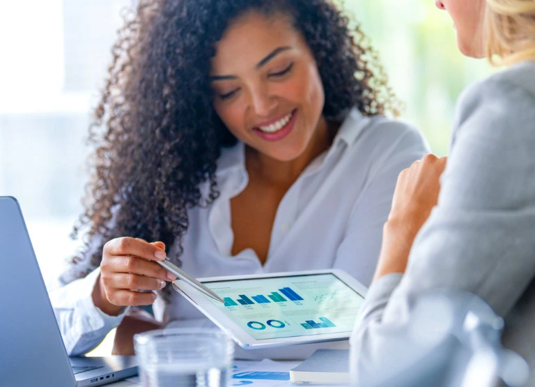 Woman smiling as she checks savings charts on ipad