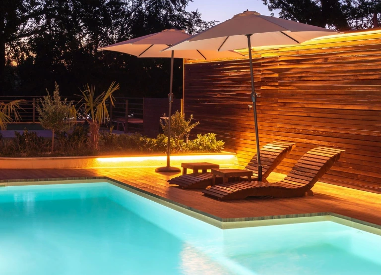 Backyard with inground pool, landscaped, lights and loungechairs