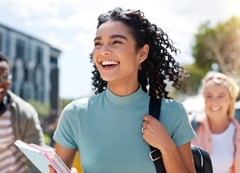 young woman smiling walking on school campus